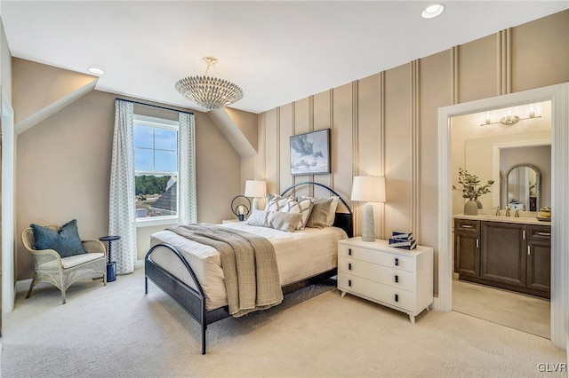 bedroom featuring ensuite bath and light colored carpet