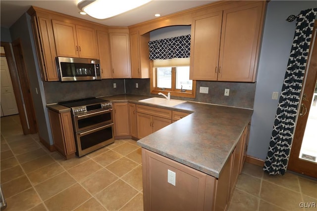 kitchen with sink, backsplash, light tile patterned floors, and stainless steel appliances