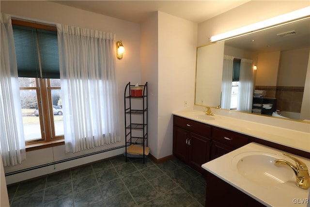 bathroom with vanity, plenty of natural light, a washtub, and a baseboard radiator