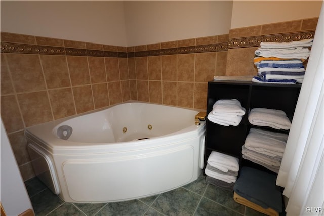 bathroom with tile patterned flooring, tile walls, and a bathtub