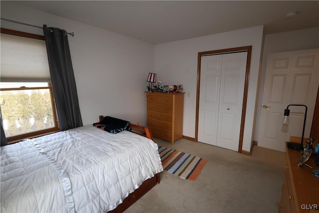 bedroom featuring light colored carpet and a closet