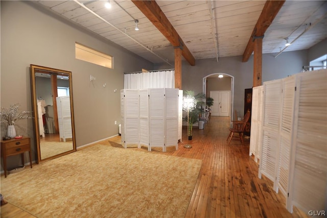 unfurnished room featuring beamed ceiling, wood ceiling, hardwood / wood-style floors, and rail lighting