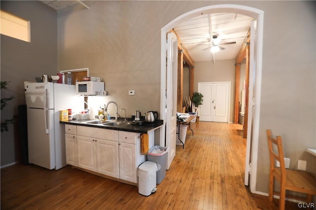 kitchen featuring white appliances, light hardwood / wood-style floors, sink, and ceiling fan