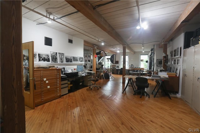 interior space featuring track lighting, light wood-type flooring, beam ceiling, and wood ceiling