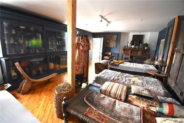 bedroom featuring hardwood / wood-style floors and rail lighting