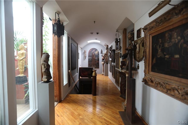 hallway featuring lofted ceiling and light hardwood / wood-style flooring