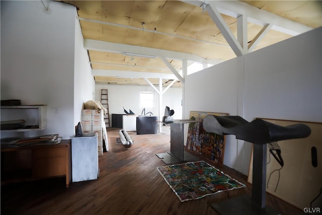 interior space with vaulted ceiling with beams and dark hardwood / wood-style flooring