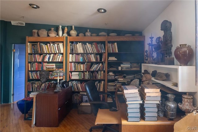 office with wood-type flooring, visible vents, and lofted ceiling