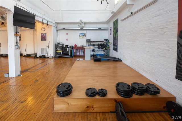 exercise area featuring a garage, wood-type flooring, visible vents, and a workshop area