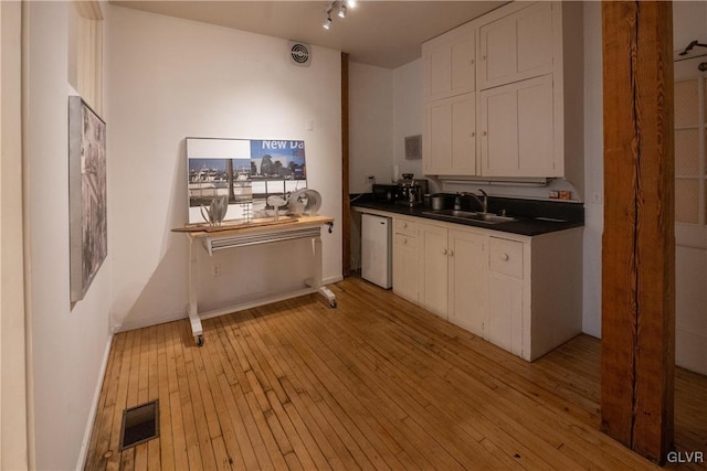 kitchen featuring white cabinets, visible vents, dishwasher, a sink, and dark countertops