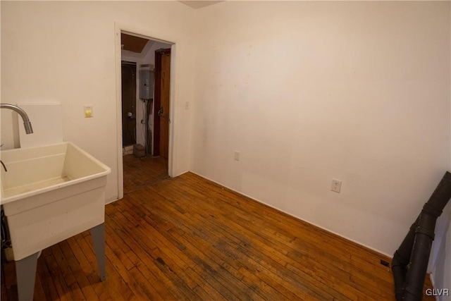 bathroom with a sink, water heater, and hardwood / wood-style flooring