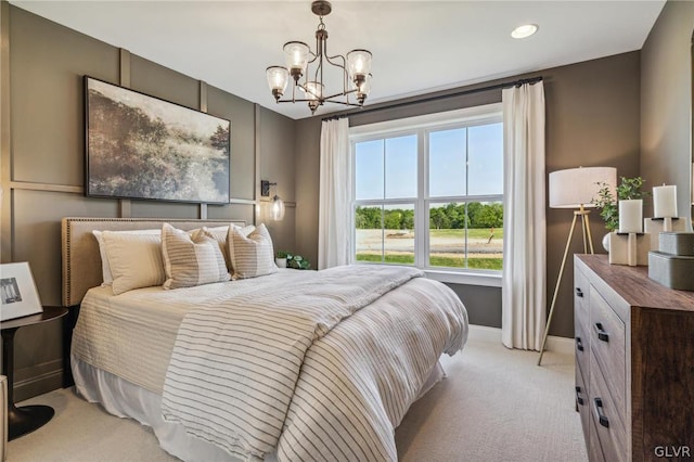 bedroom featuring light carpet and an inviting chandelier