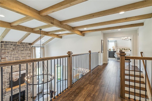 hall featuring dark hardwood / wood-style floors, vaulted ceiling with beams, and a chandelier