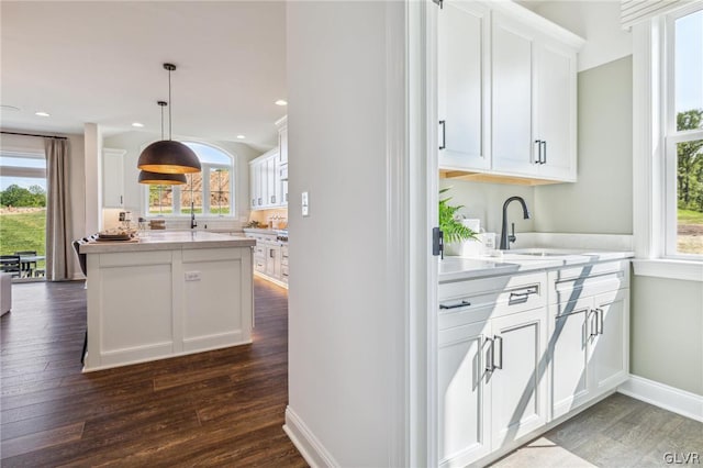 kitchen with plenty of natural light, sink, dark wood-type flooring, and white cabinetry