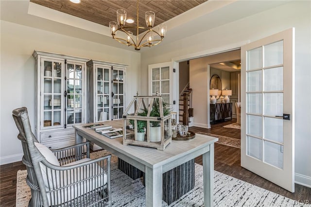 interior space with wood ceiling, dark hardwood / wood-style floors, a tray ceiling, and a notable chandelier