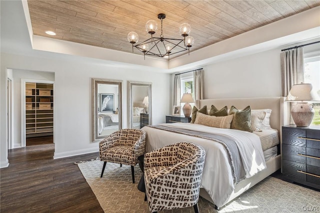 bedroom featuring a closet, a spacious closet, hardwood / wood-style flooring, a tray ceiling, and wood ceiling