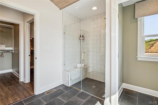 bathroom featuring a shower with shower door and tile patterned floors