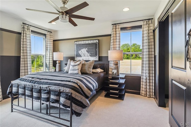 bedroom with multiple windows, light colored carpet, and ceiling fan