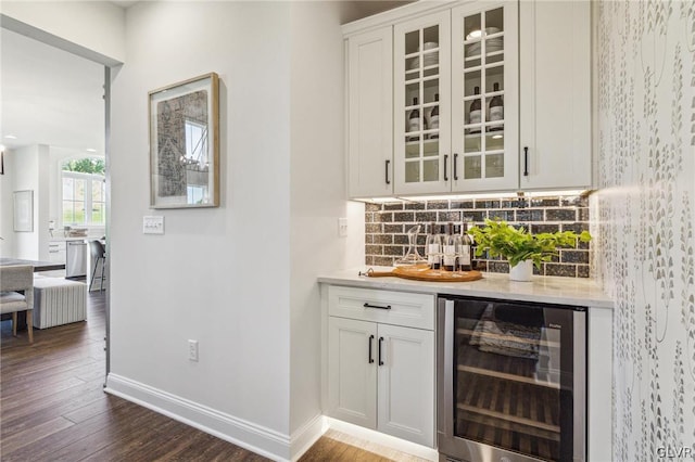 bar with white cabinetry, beverage cooler, dark hardwood / wood-style flooring, and backsplash