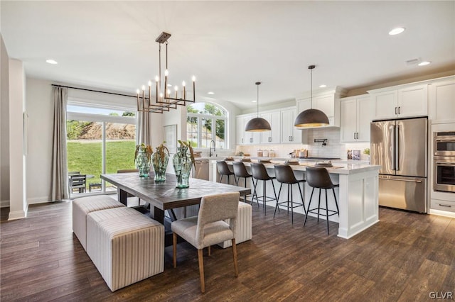 dining space featuring dark hardwood / wood-style floors, sink, and an inviting chandelier