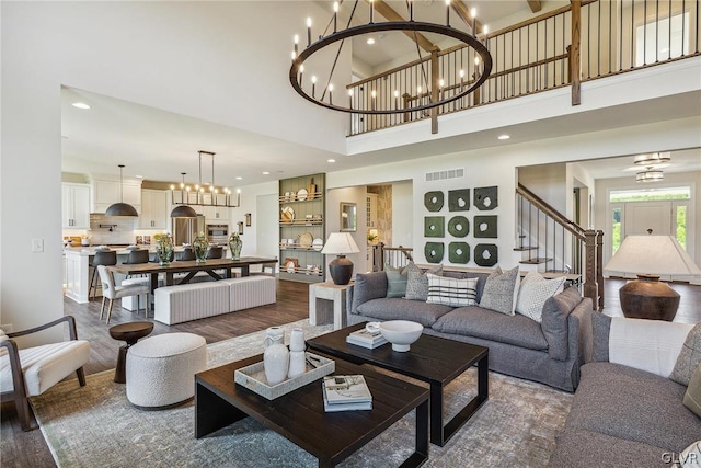 living room with a high ceiling, dark wood-type flooring, and a chandelier