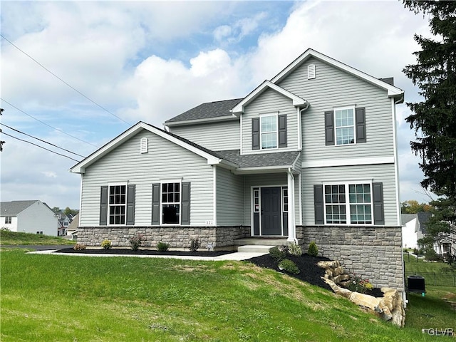 view of front of house with central AC and a front lawn