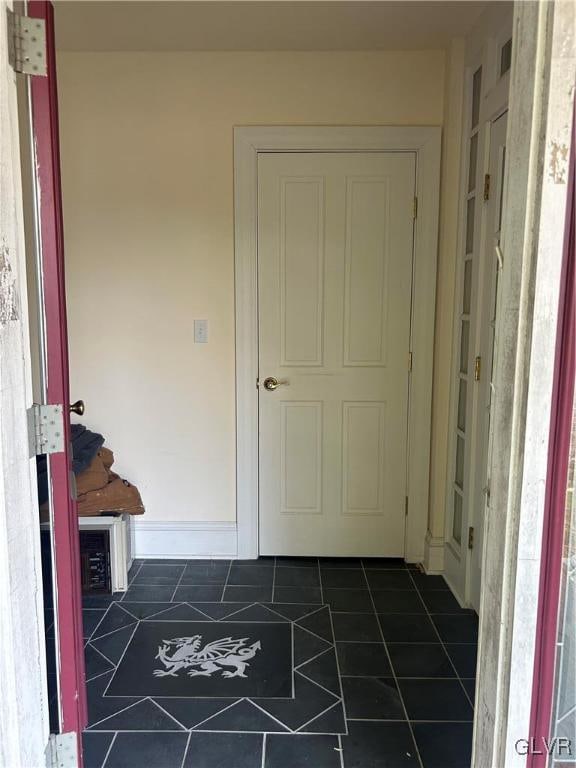 hallway with dark tile patterned flooring