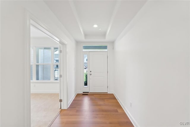 doorway featuring wood-type flooring and a raised ceiling