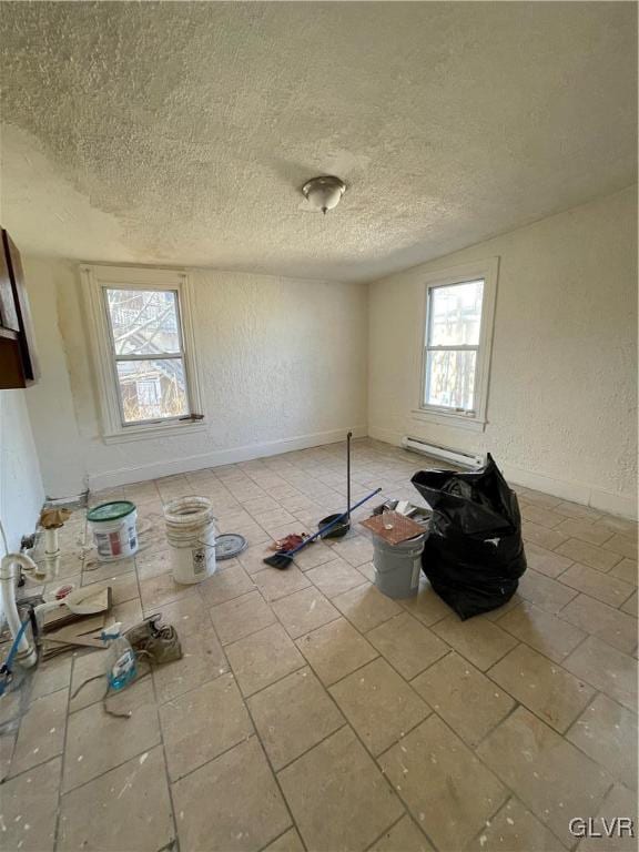 interior space featuring a textured ceiling and baseboard heating