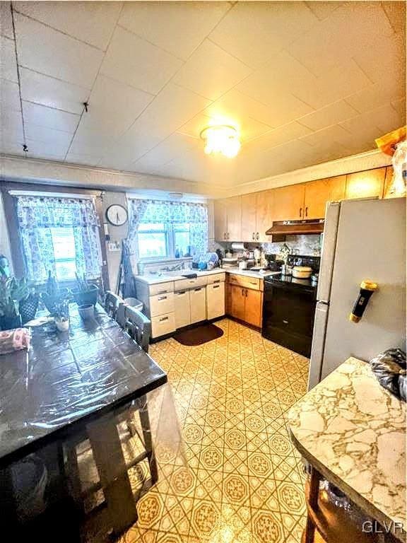 kitchen with electric range and white fridge