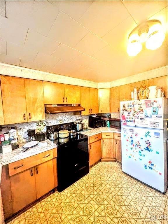 kitchen featuring backsplash, white fridge, and black range with electric cooktop