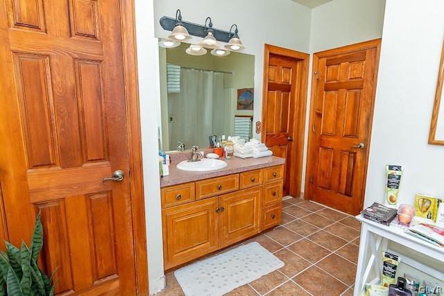 bathroom featuring tile patterned flooring, vanity, and curtained shower