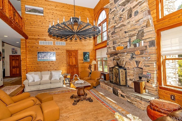 living room featuring a high ceiling, a fireplace, and wood walls