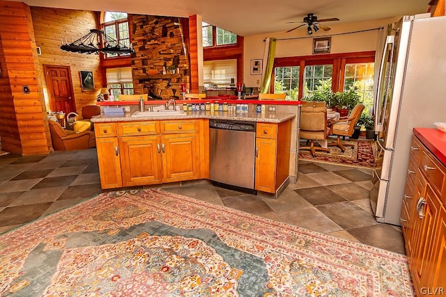 kitchen featuring kitchen peninsula, white fridge, ceiling fan, stainless steel dishwasher, and sink