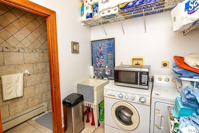 clothes washing area with washing machine and dryer, a sink, baseboard heating, laundry area, and light tile patterned floors