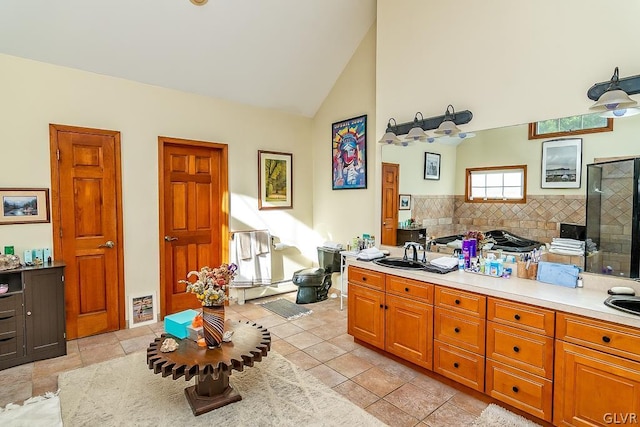 full bath featuring high vaulted ceiling, tiled shower, backsplash, a sink, and visible vents