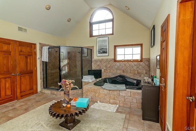 bathroom with plus walk in shower, tile walls, and high vaulted ceiling