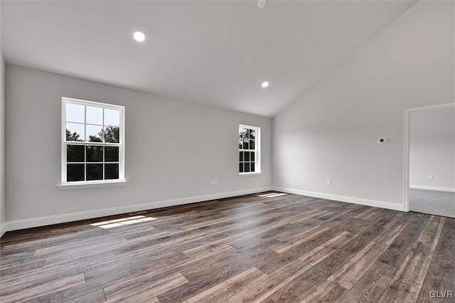 spare room with hardwood / wood-style floors and high vaulted ceiling