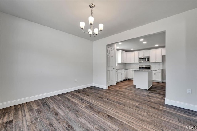 unfurnished living room with dark hardwood / wood-style flooring and a chandelier