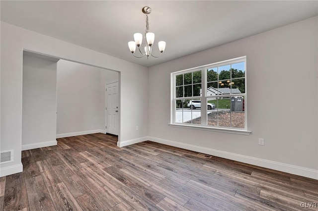 unfurnished room featuring hardwood / wood-style floors and an inviting chandelier