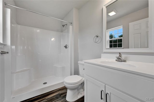 bathroom featuring toilet, hardwood / wood-style floors, a shower, and vanity