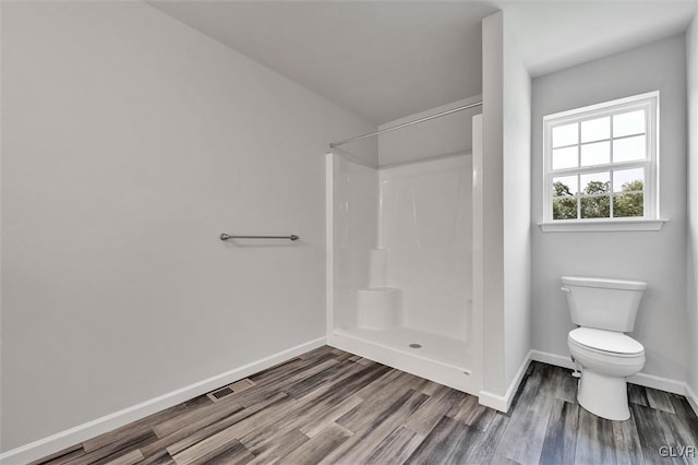 bathroom featuring toilet, hardwood / wood-style floors, and walk in shower