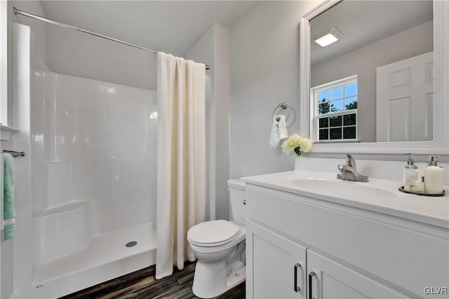 bathroom featuring hardwood / wood-style flooring, a shower with shower curtain, vanity, and toilet