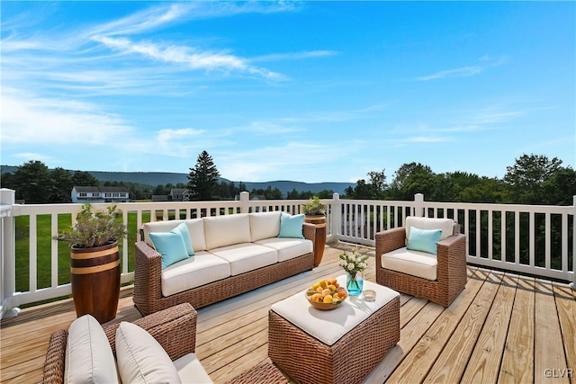 wooden deck featuring an outdoor living space and a mountain view