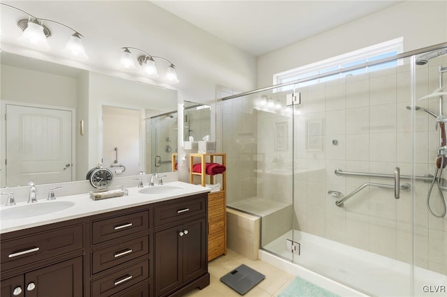 bathroom featuring a shower with shower door, vanity, and tile patterned floors