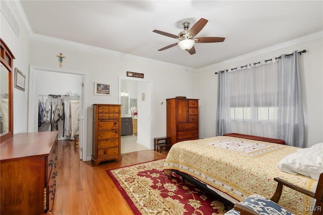 bedroom featuring light wood-type flooring, crown molding, ceiling fan, a closet, and ensuite bathroom