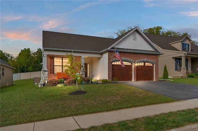 view of front of property with a garage and a lawn