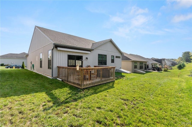 rear view of property with a yard and a wooden deck