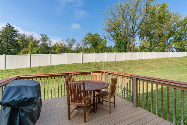 wooden deck featuring a grill and a lawn