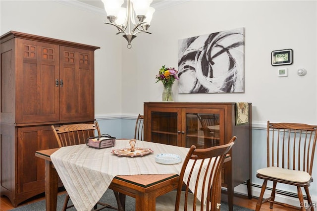 dining space with crown molding, a baseboard radiator, and a chandelier